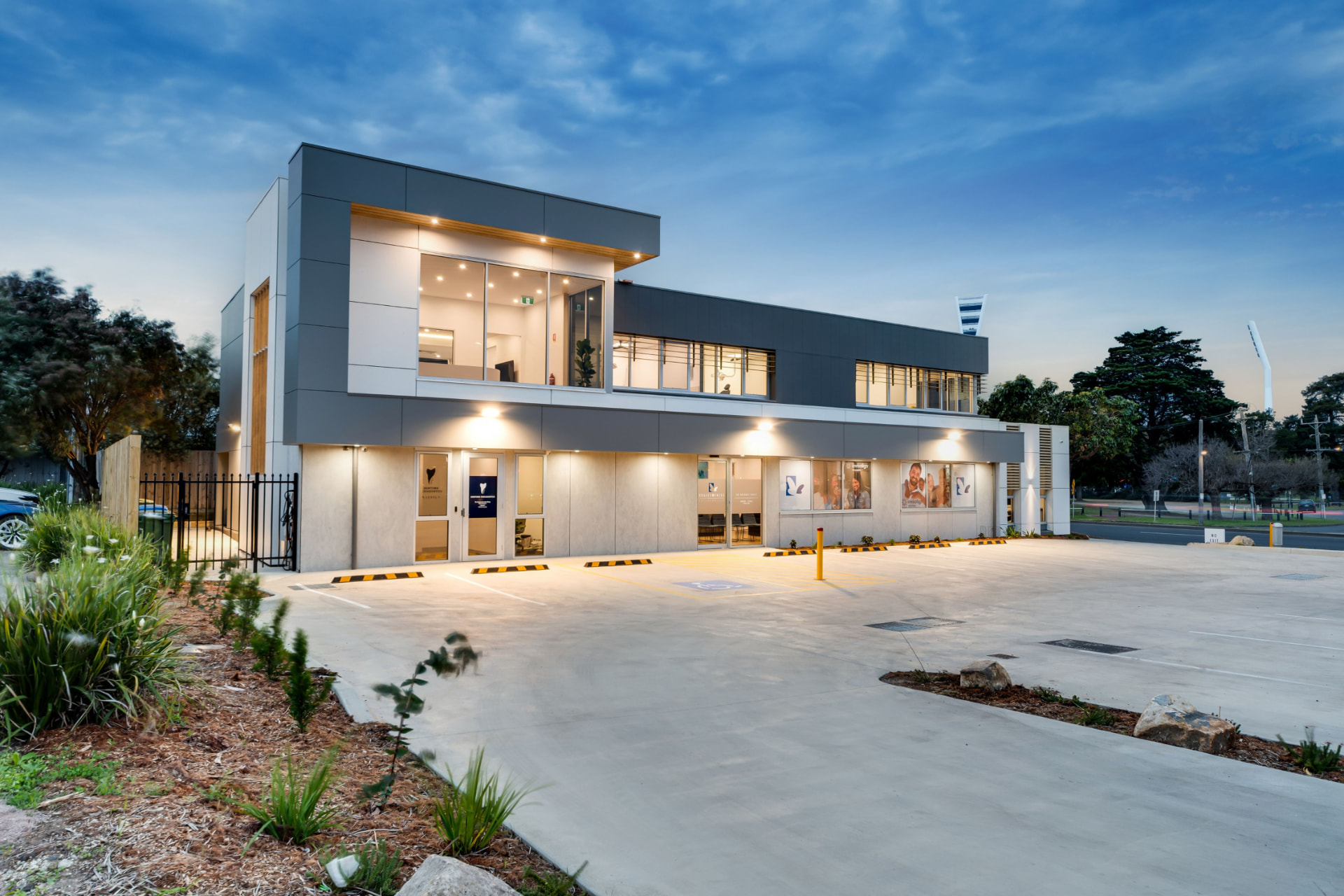 Modern commercial building with illuminated entrance at dusk